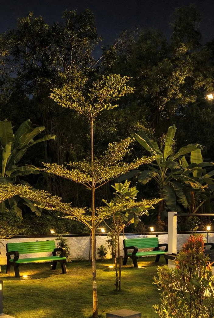 Illuminated guest house garden with seating at night